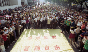 圖1｜1990年12月26日集結萬人的民進黨｢1225大遊行｣隊伍，遊行群眾手持鮮花、頭綁黃布條，表達強烈主張之外的柔性訴求。(張家榮/攝)